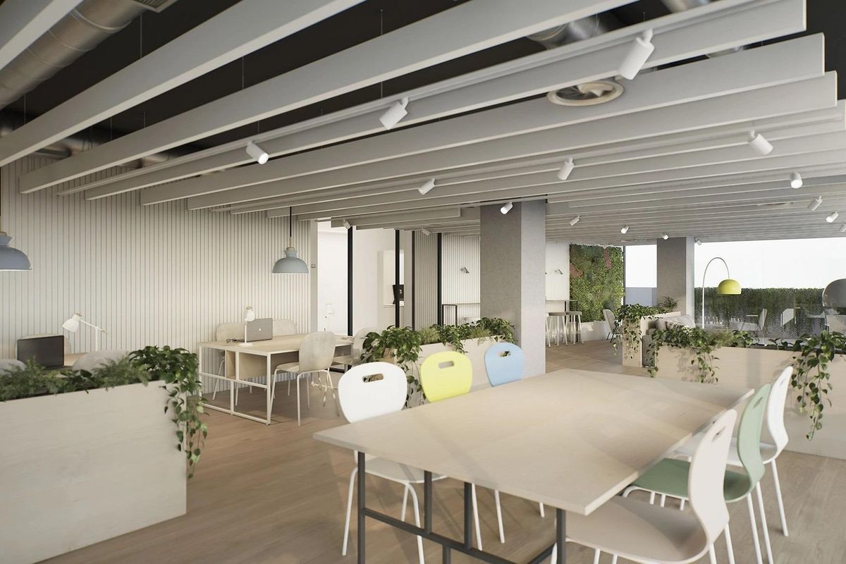 Heldere gemeenschappelijke woonkamer met tafels en groen in een modern gebouw in Mijas, Costa del Sol.