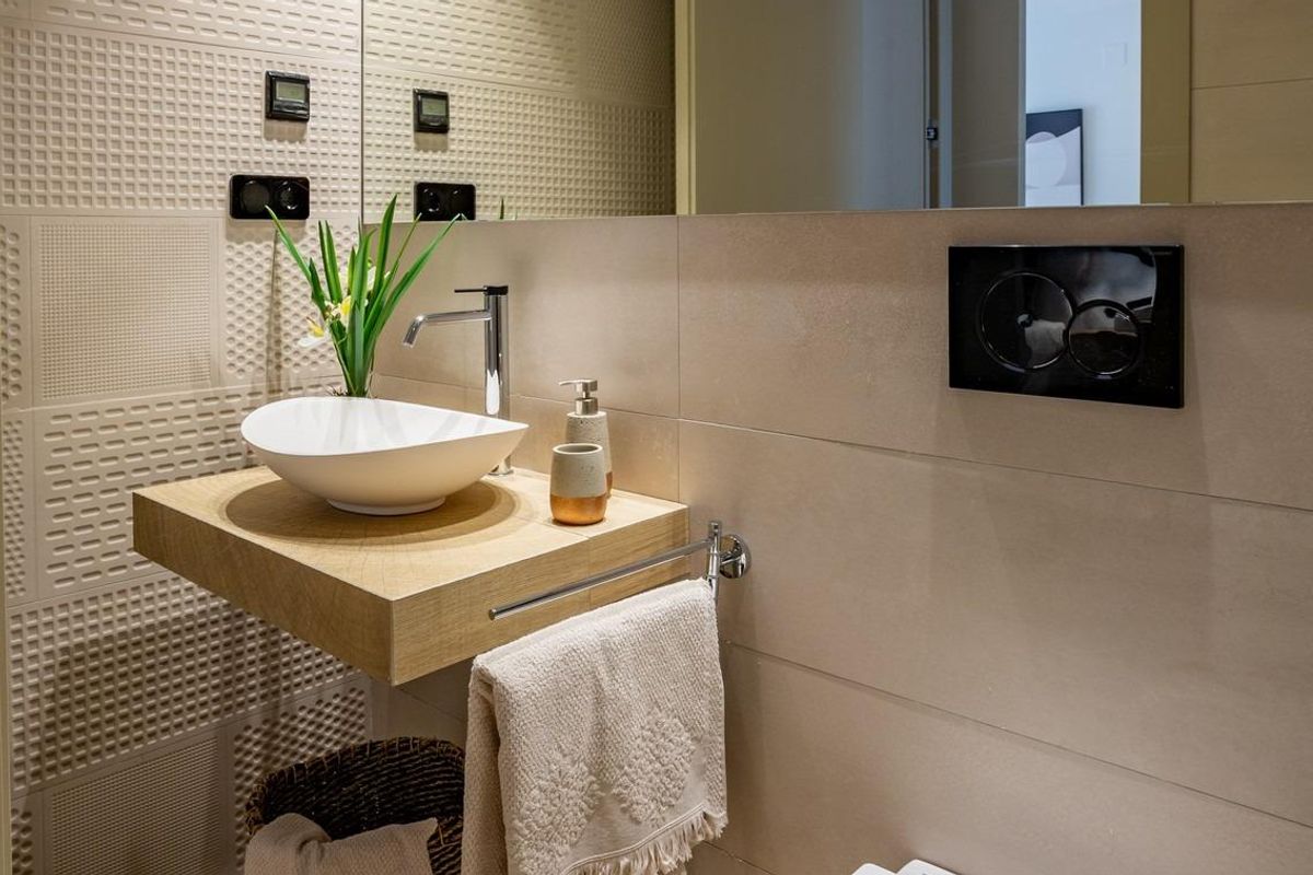 Stijlvolle badkamer met een wastafel en decoratieve elementen in een appartement op de begane grond in Algorfa.