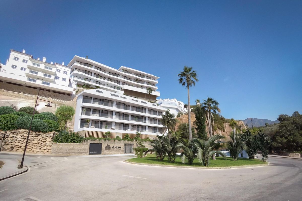 Modern appartementengebouw in Fuengirola, met aangelegde tuinen en palmbomen.