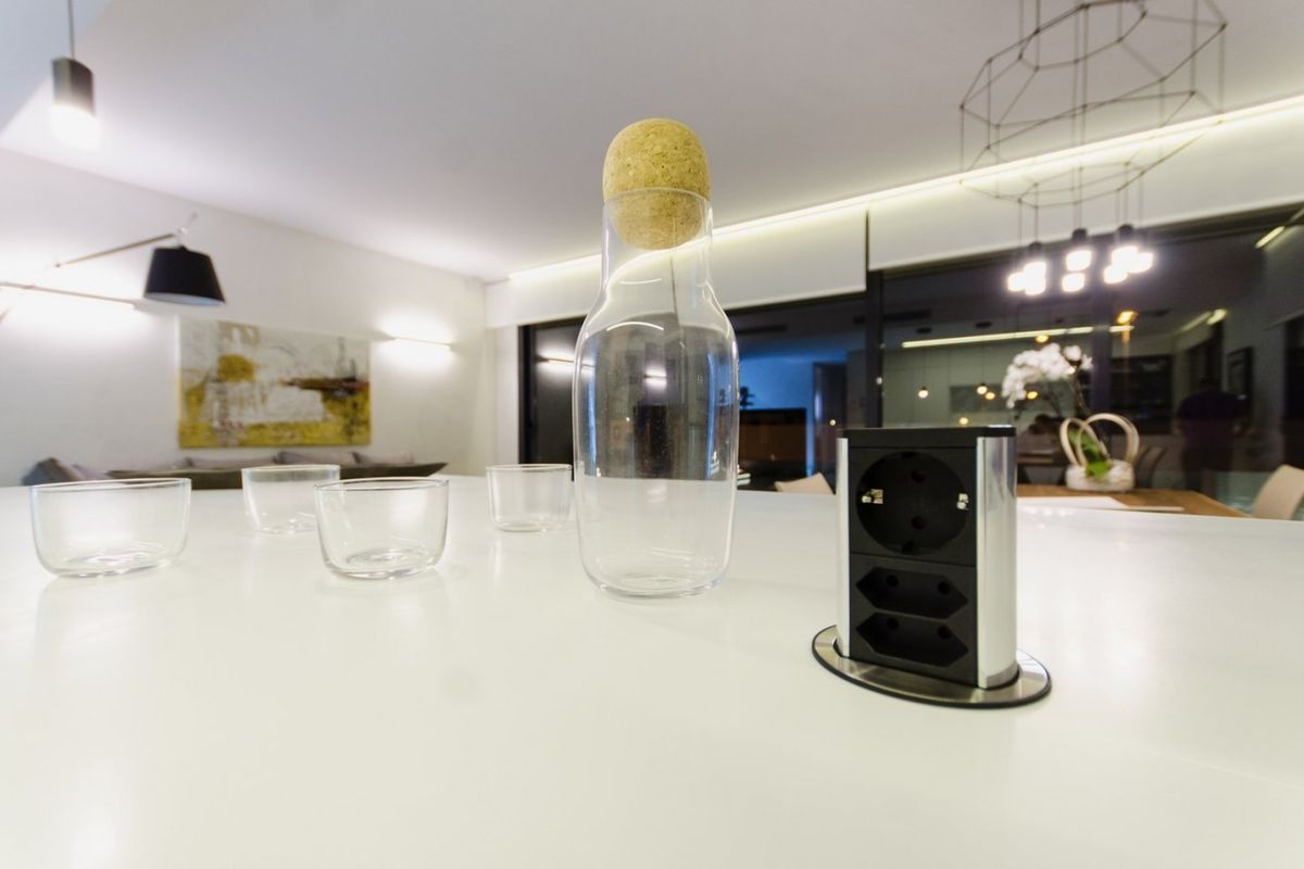 Een close-up van een moderne keukentafel met een glazen karaf en kopjes in een stijlvol villa in Orihuela Costa.