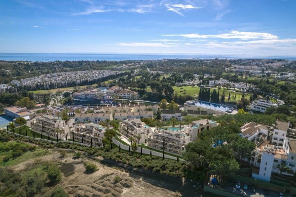 Luchtfoto van een nieuw wooncomplex in Marbella, met tuinen en nabijheid van de kust.