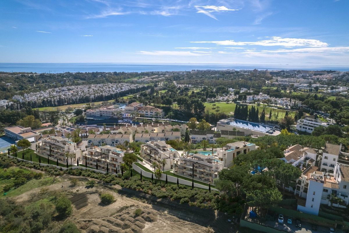Luchtfoto van een luxe appartementencomplex in Marbella, omringd door groen en dicht bij de kust.