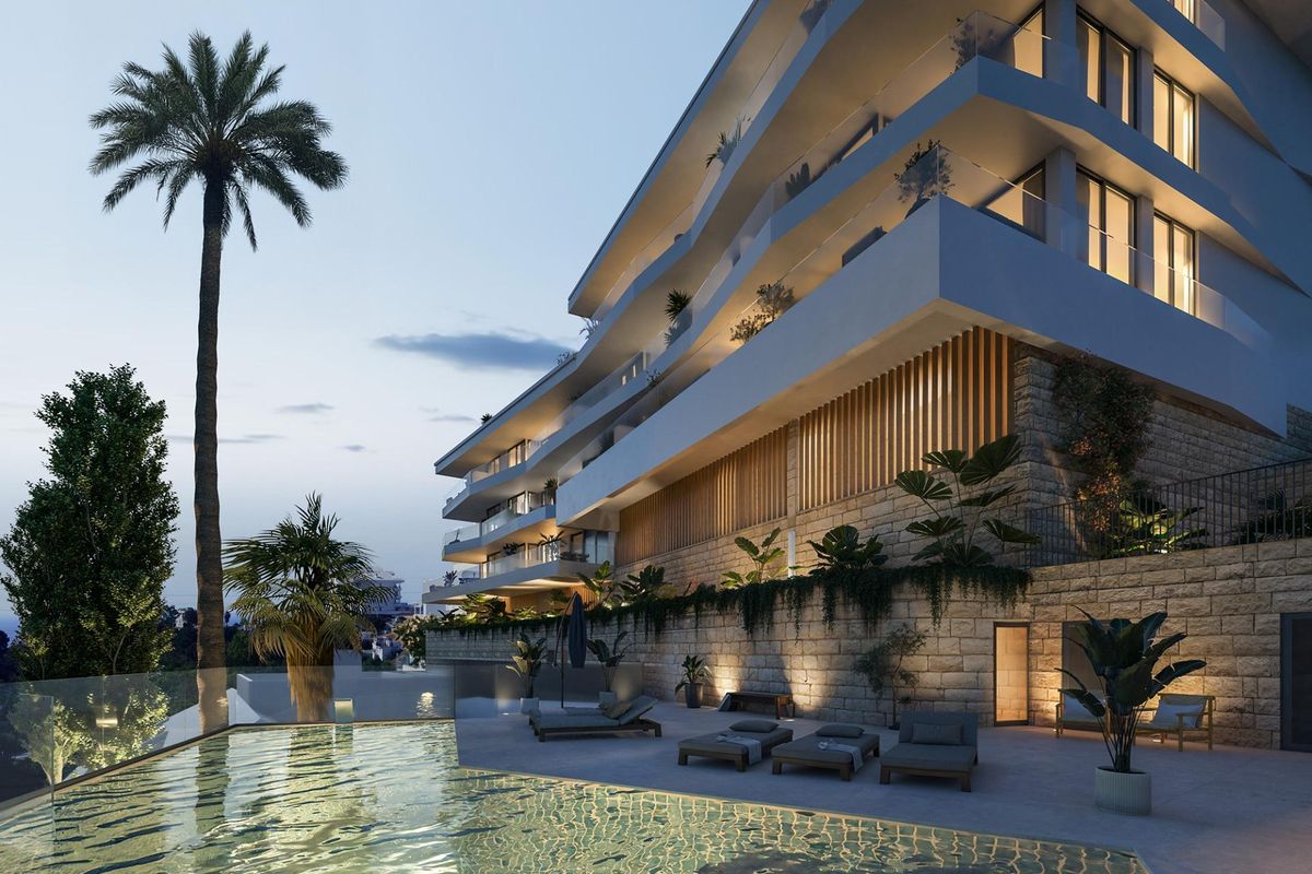 Buitenzicht op een modern appartementencomplex met een zwembad en palmbomen in Fuengirola, Costa del Sol.