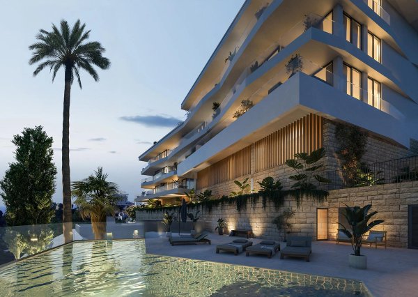 Buitenzicht op een modern appartementencomplex met een zwembad en palmbomen in Fuengirola, Costa del Sol.