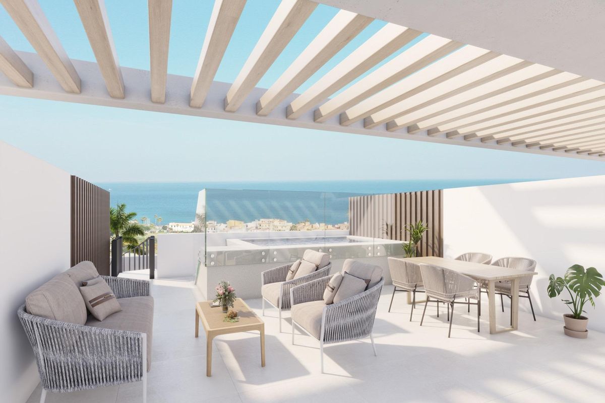 Ruim terras met uitzicht op zee, zithoek en eetruimte in een 3-slaapkamer appartement in Manilva, Costa del Sol.