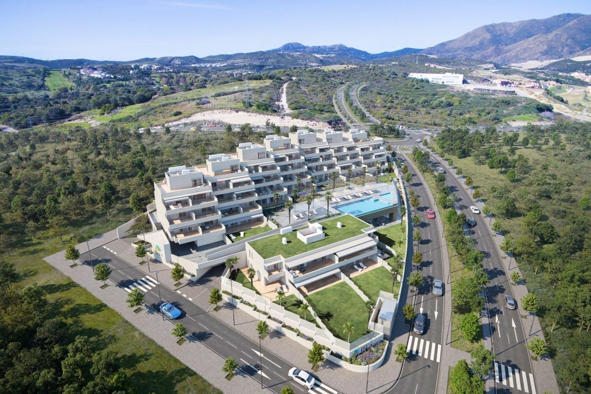 Luchtfoto van modern appartementencomplex met tuinen en zwembad, genesteld in het schilderachtige Estepona.