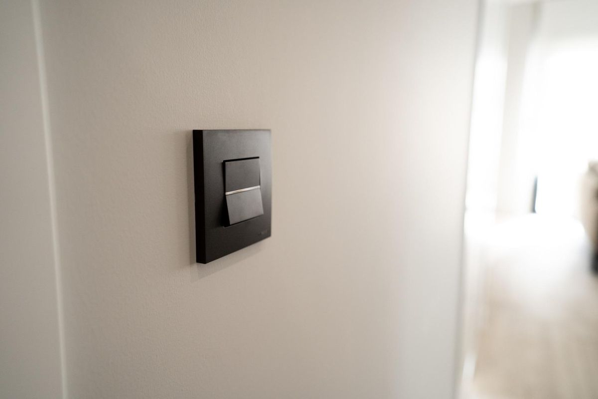 Eenvoudige lichtschakelaar op een muur in de 3-slaapkamer bungalow die de open indeling in Pilar de La Horadada, Spanje, onthult.