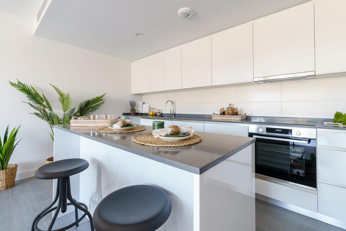 Strakke keuken met moderne apparatuur en een ontbijtbalk in het penthouse in Mijas.