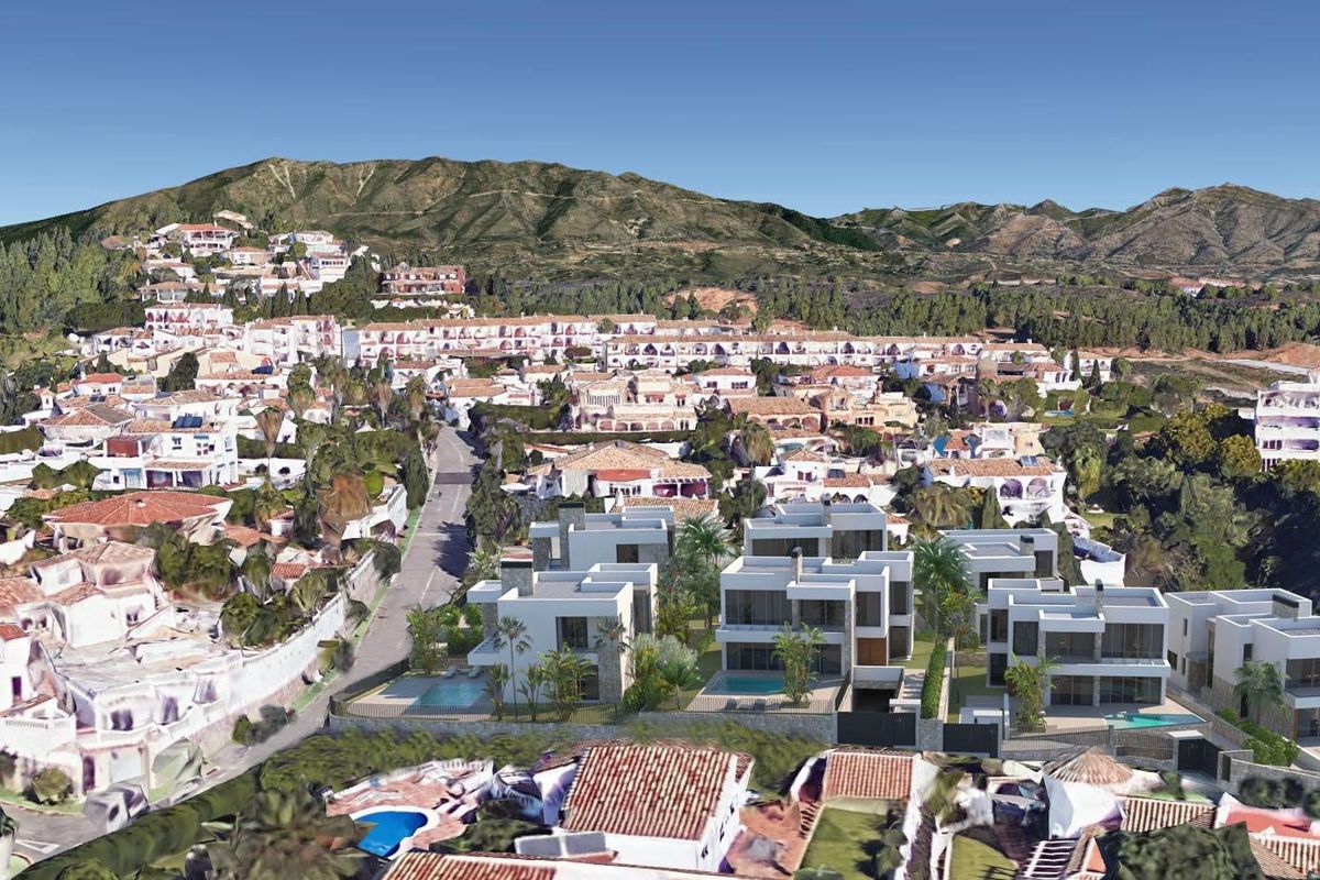 Prachtige luchtfoto van villa's in Mijas, Costa del Sol, met heuvels en kustontwikkelingen.