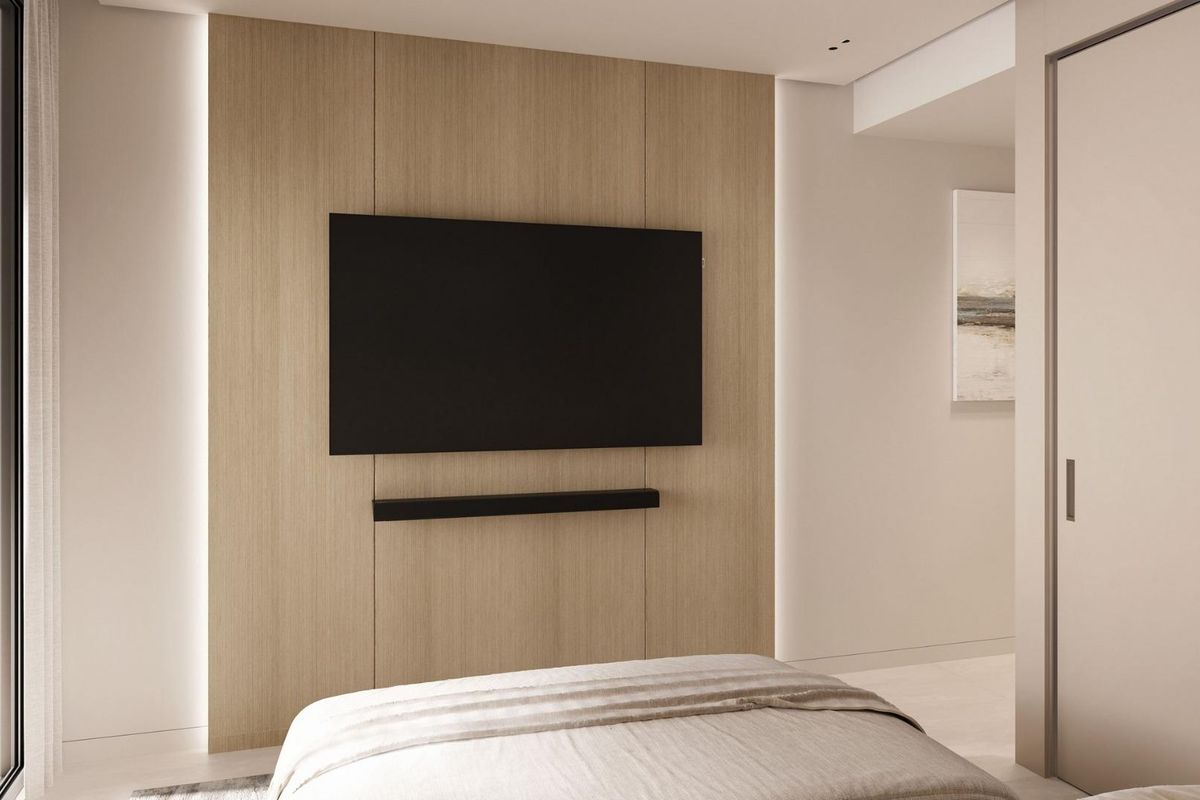 Gezellige hoek in de slaapkamer, met een gemonteerde tv en warme houten accenten, Estepona.