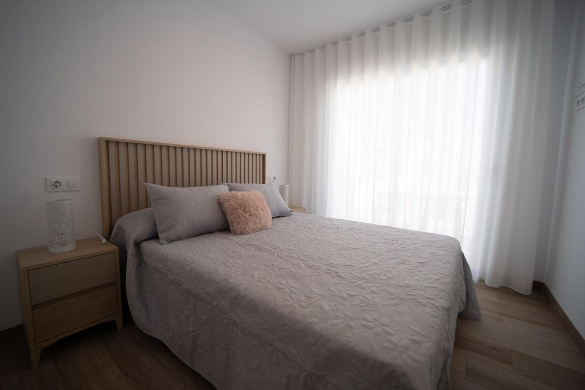 Bedroom interior with double bed in a 3-bed townhouse in San Javier. Neutral color palette with a bright window.