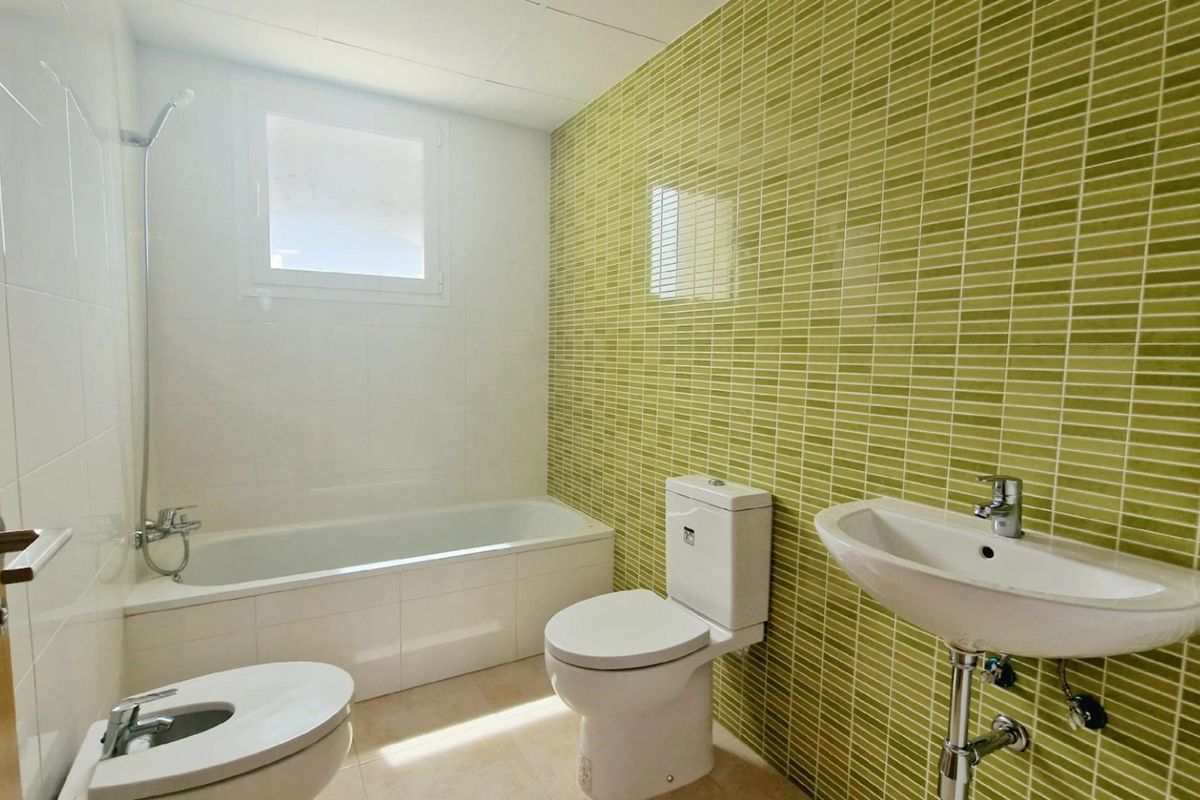 Moderne badkamer met groene tegels in de 4-slaapkamer villa in Lorca, met een bad en wastafel.