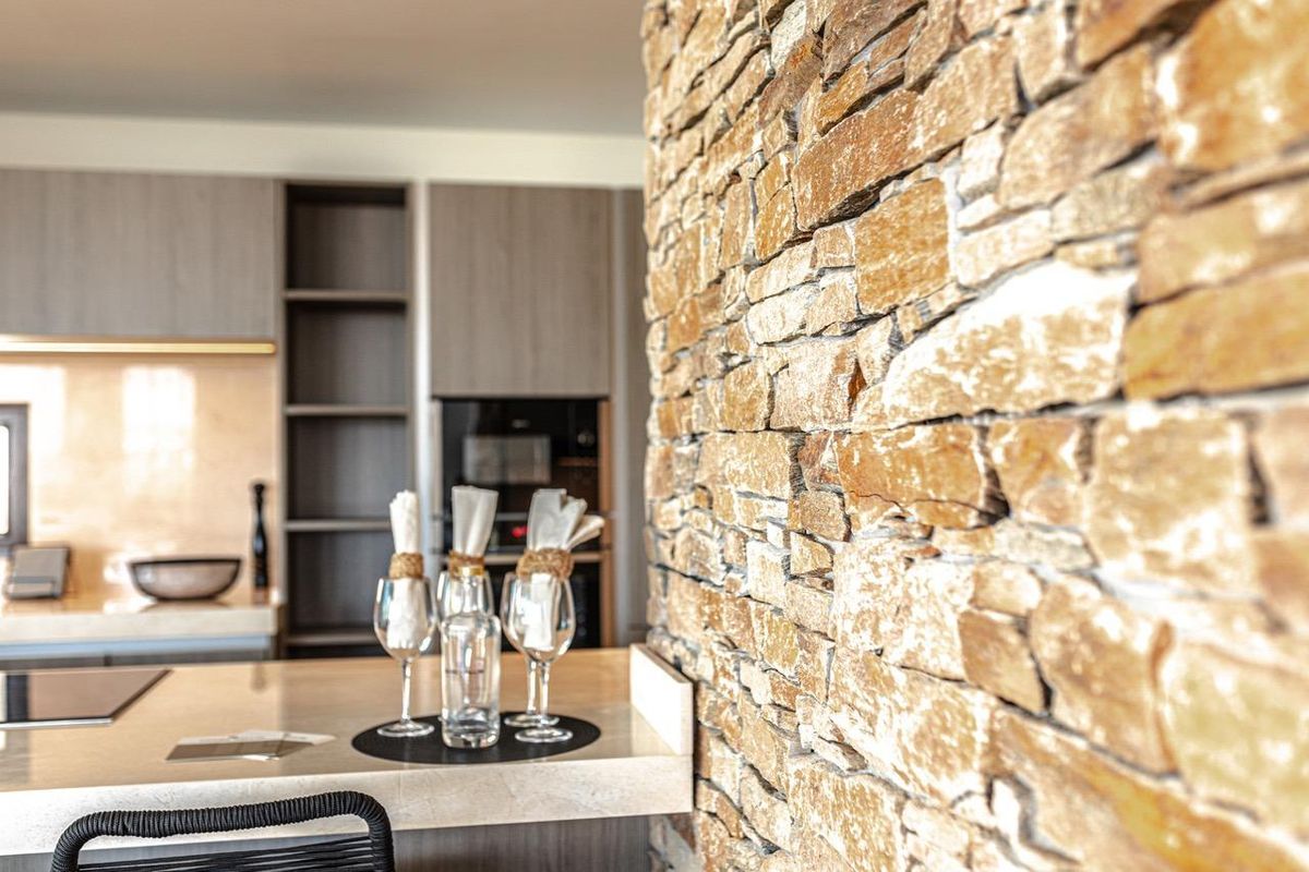 Close-up van keuken details, met elegante stenen muren en eetopstelling in de villa in Benahavís.