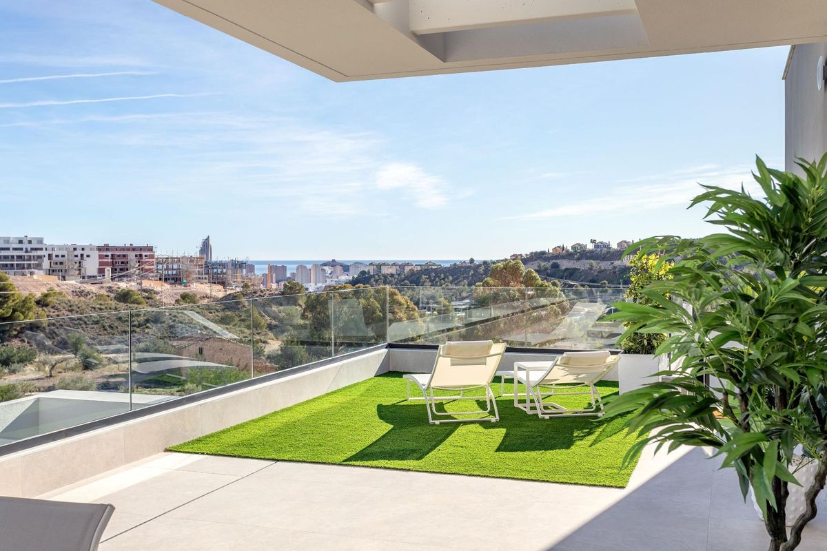 Terras met ligbedden en groene tuin, met uitzicht in Finestrat, Costa Blanca Noord, appartement.