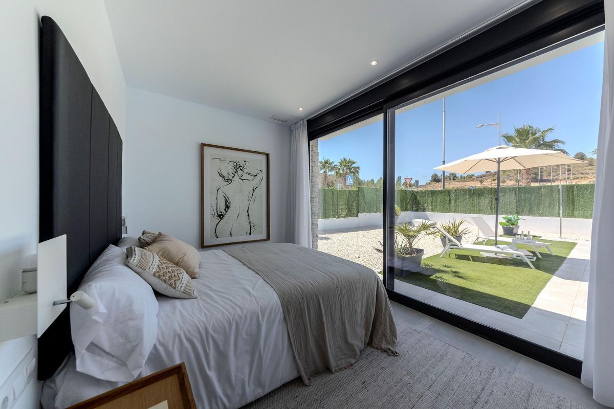 Hoofdslaapkamer met uitzicht op de tuin in een 3-slaapkamer villa in Calasparra, met grote glazen deuren.