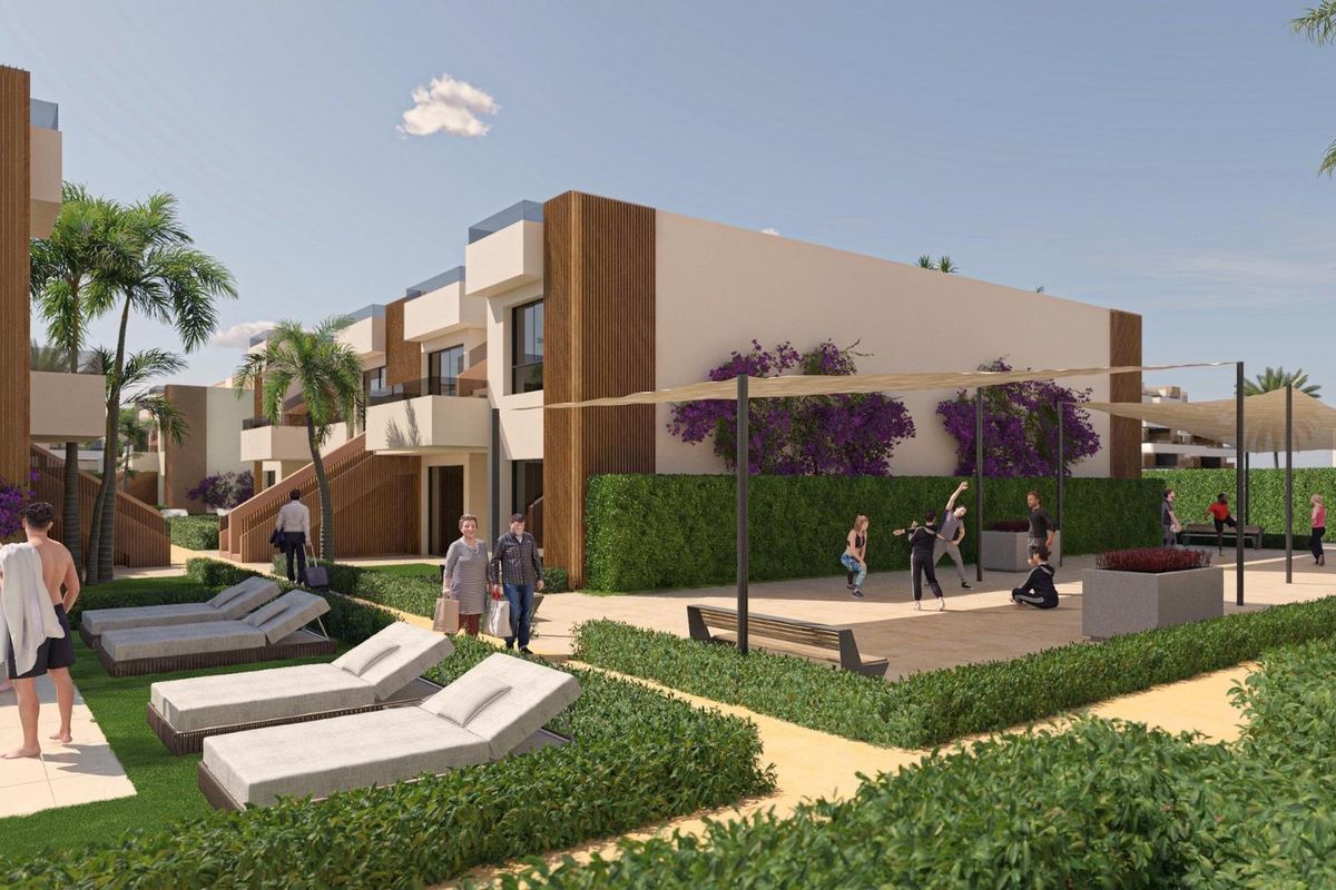 A vibrant community area in Alhama De Murcia with lounging spaces and palm trees near a modern bungalow complex.