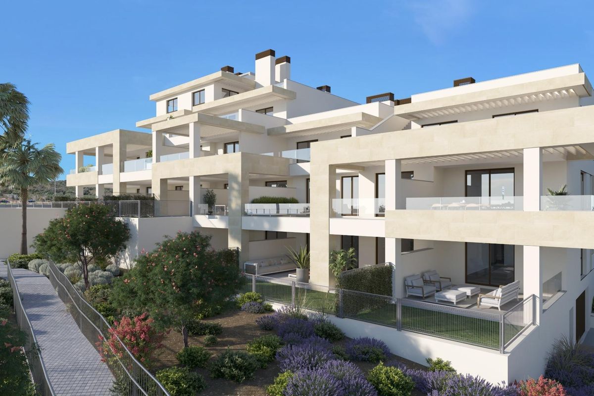 Buitenzicht op de stijlvolle penthouses in Estepona met terrassen, omgeven door weelderig groen en palmbomen.
