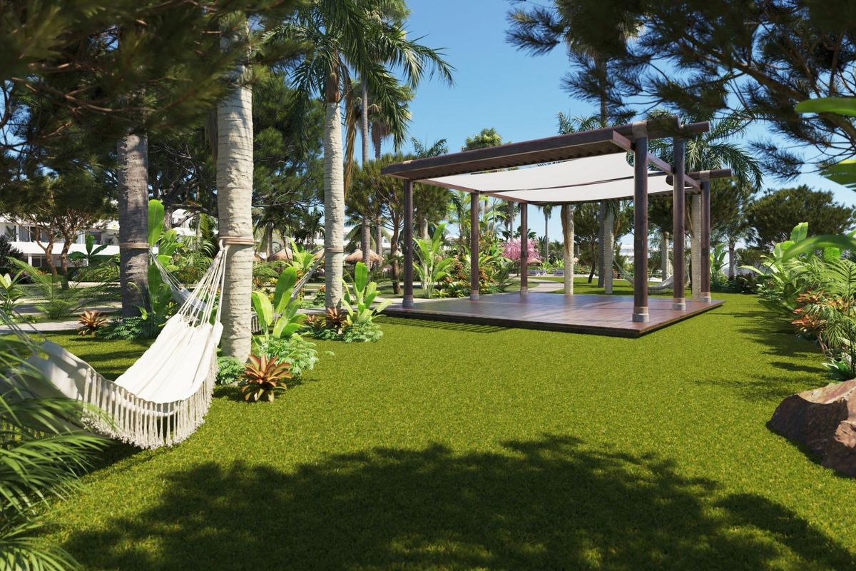 Ontspannende tuinruimte met een hangmat en pergola in het appartementcomplex in San Roque.