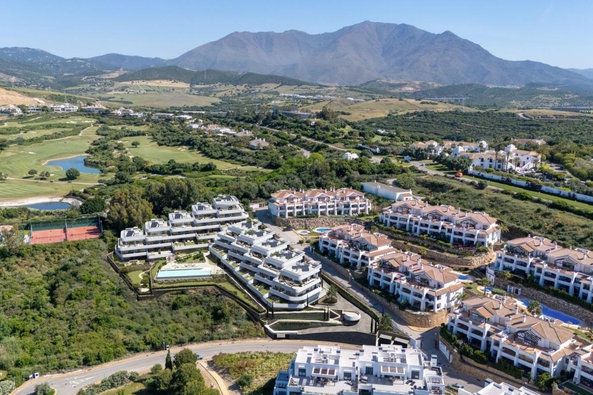 Luchtfoto van een modern residentieel complex in Casares, met golfbanen en berglandschappen.