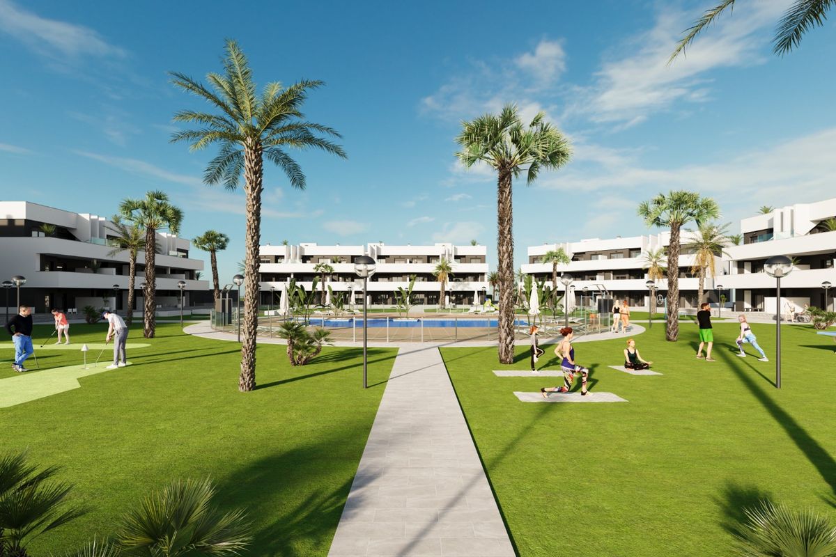 Modern residentieel complex met palmbomen, groen gazon en zwembad in Guardamar del Segura, Costa Blanca