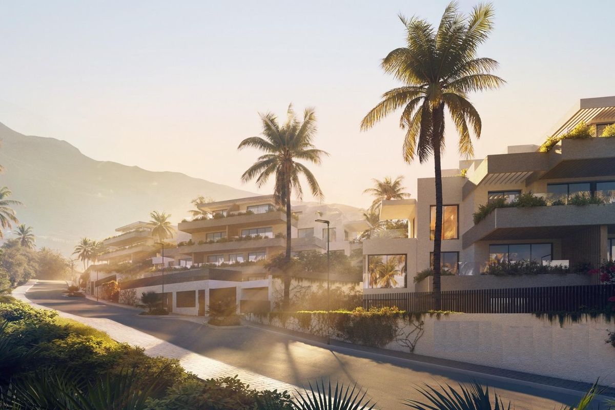 Pittoresk uitzicht op palmboom straat naar moderne 2-slaapkamer appartementen in Mijas tijdens zonsondergang.