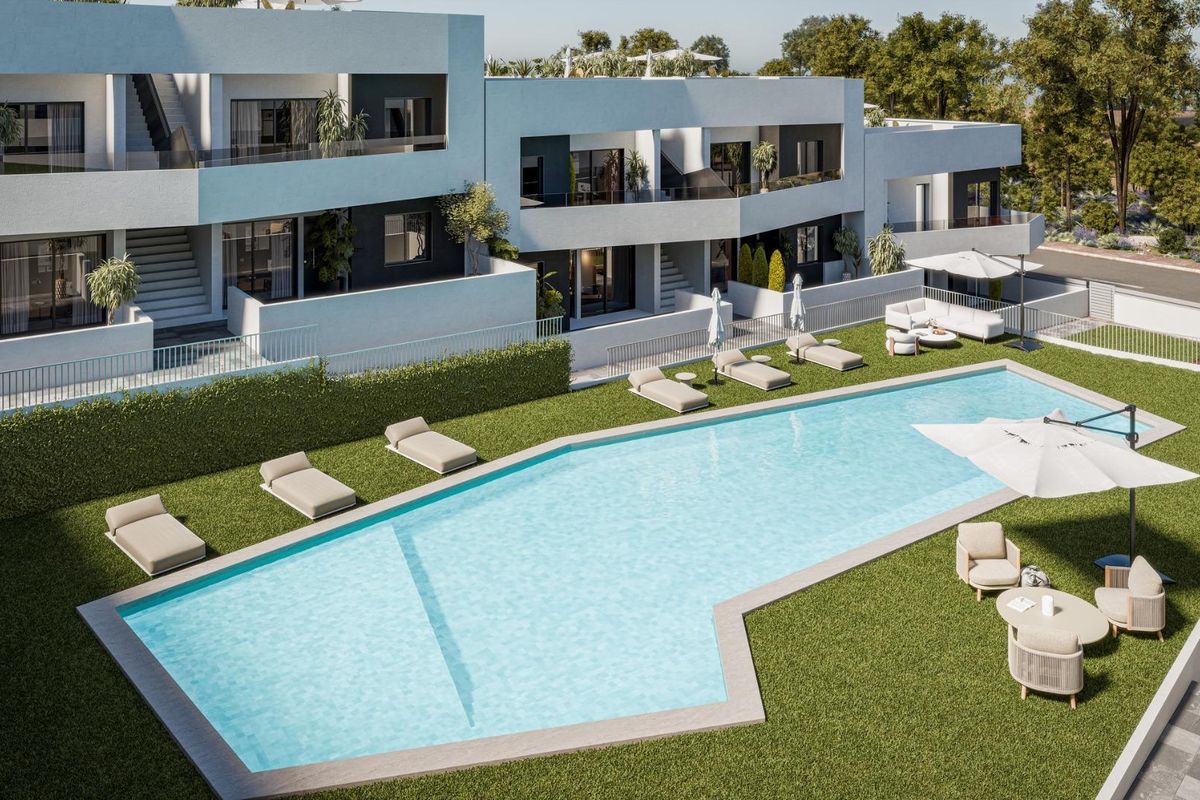 Buitenzwembad van een modern complex in San Miguel de Salinas, met ligbedden en aangelegde tuinen.