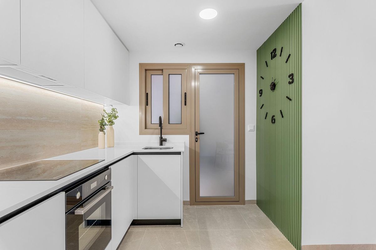 Moderne keuken met strak design en een groene accentmuur in een 3-slaapkamer penthouse in Jacarilla.