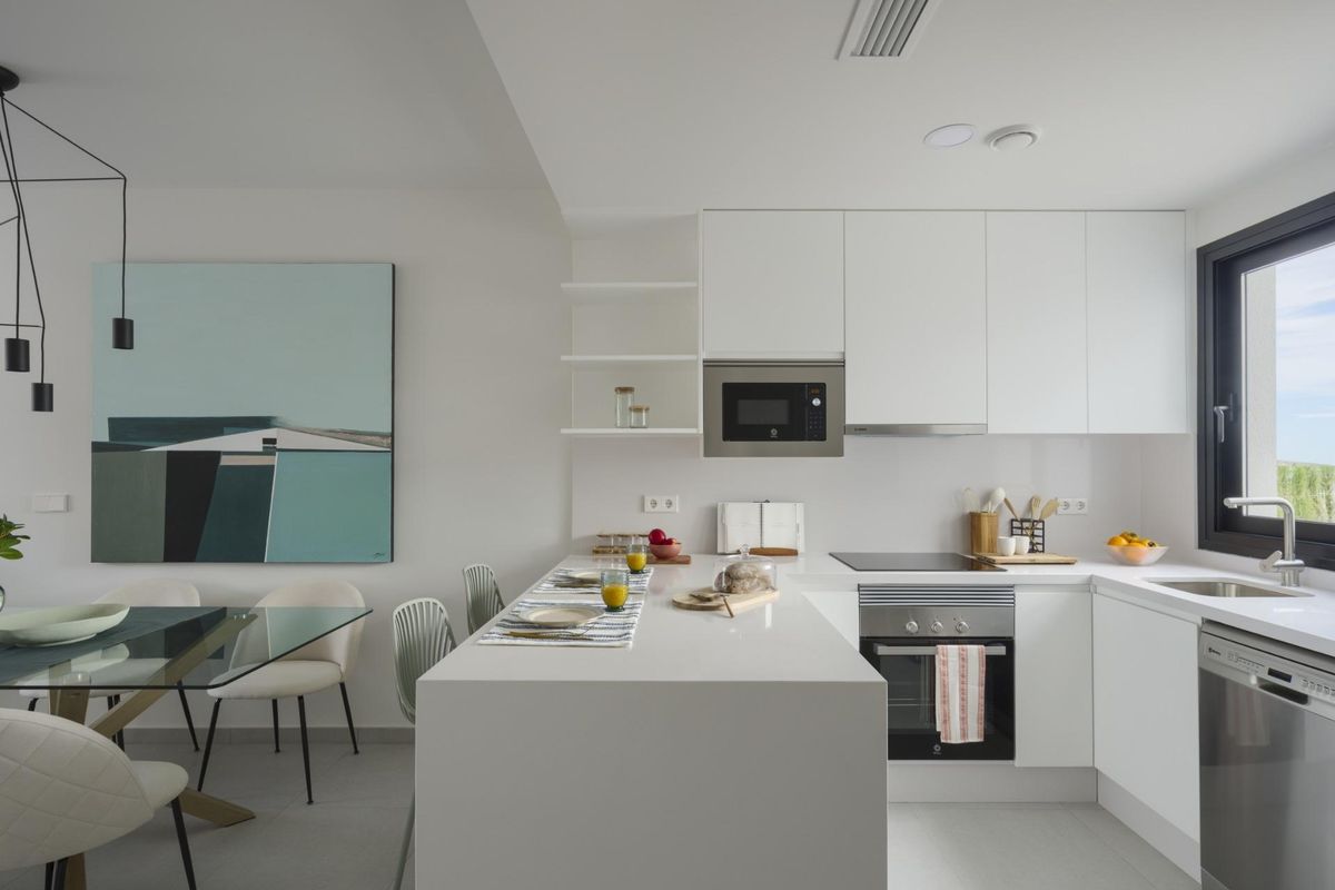 Stijlvolle keuken met eigentijdse afwerkingen en een ontbijtbar in de rijwoning van Baños y Mendigo.