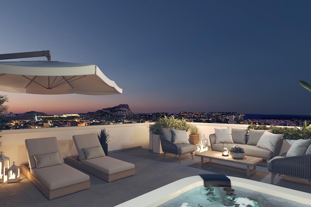 Terras in de nacht met ligstoelen en een jacuzzi, ideaal om te ontspannen in het penthouse in Alicante.