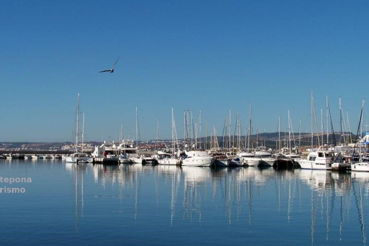Rustig uitzicht op de jachthaven in Estepona, met jachten en boten die in het water reflecteren onder een heldere lucht.