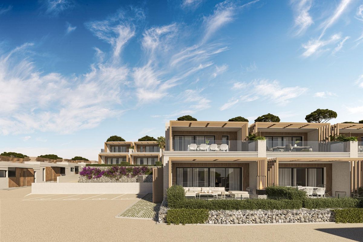 Vooraanzicht van een moderne 4-slaapkamer townhouse in Mijas, Costa del Sol, met een terras en aangelegde omgeving.