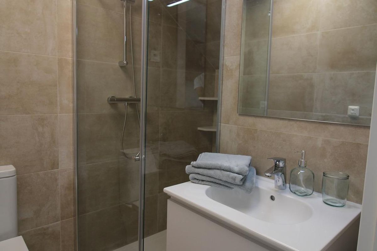 Moderne badkamer met glazen douche, neutrale tegels en elegante wastafel in een 3-slaapkamer herenhuis in Pilar de La Horadada.