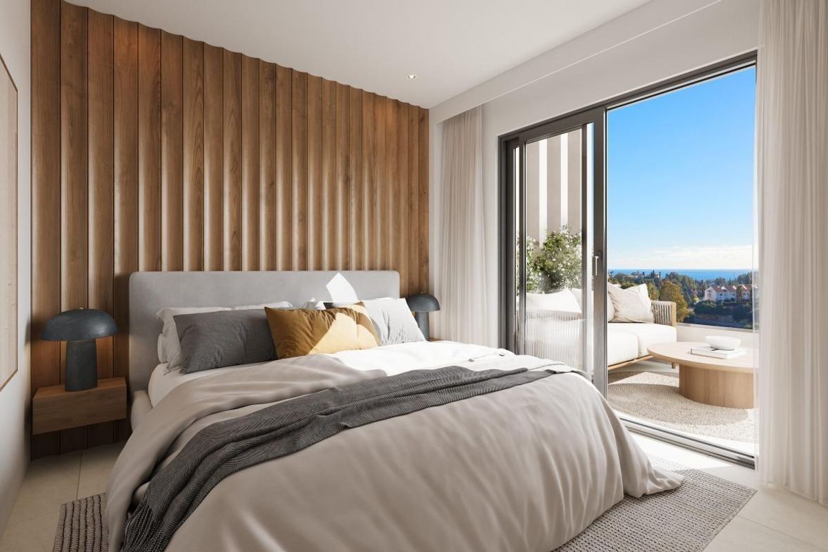 Stijlvolle slaapkamer met houten wanden en grote ramen met uitzicht in een 3-slaapkamer appartement in Mijas.
