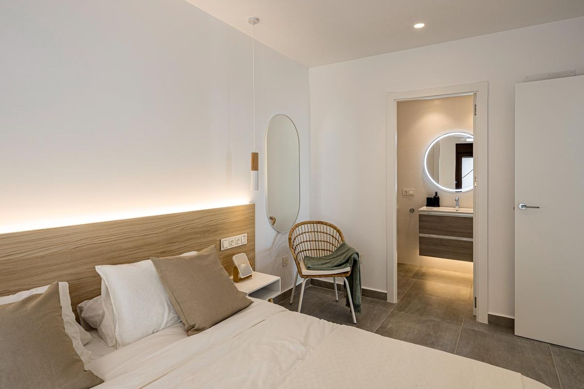Heldere slaapkamer met toegang tot een ensuite badkamer in een stijlvol appartement op de begane grond in Pilar de La Horadada.