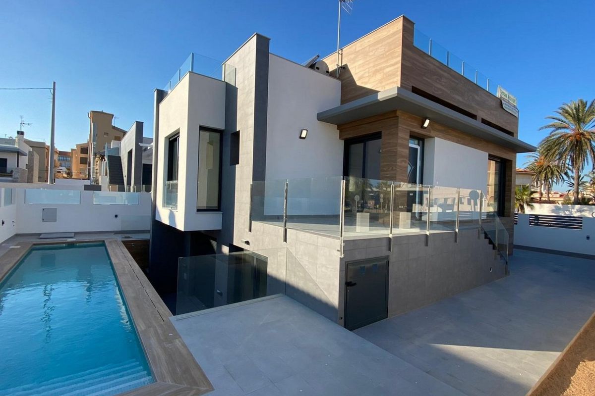 Moderne 4-slaapkamer villa in Torrevieja met een zwembad, terras en een hedendaags ontwerp onder een blauwe lucht.