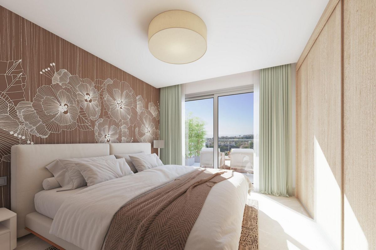 Heldere en luchtige slaapkamer met bloemenaccenten en toegang tot een balkon, onderdeel van een 3-slaapkamer penthouse in Costa del Sol, Spanje.