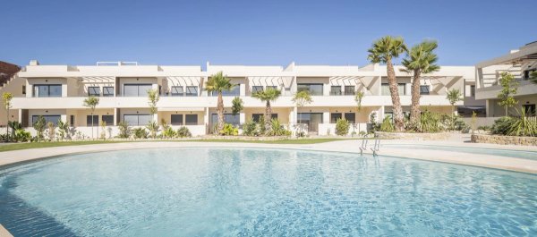 Buitenkant van een moderne bungalow met palmbomen en een zwembad in Torrevieja, Costa Blanca Zuid.