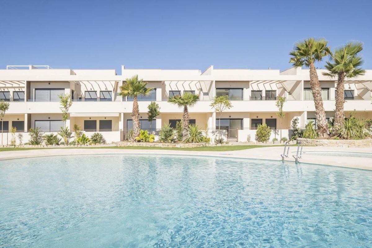 Buitenkant van een moderne bungalow met palmbomen en een zwembad in Torrevieja, Costa Blanca Zuid.