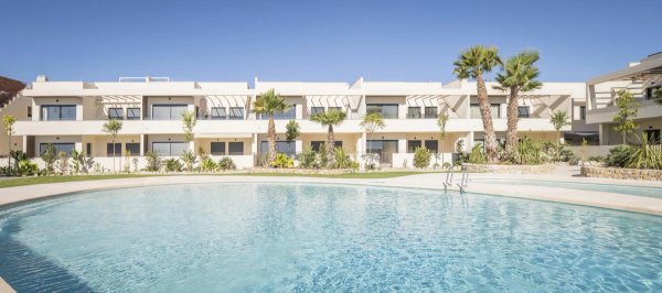 Buitenkant van een moderne bungalow met palmbomen en een zwembad in Torrevieja, Costa Blanca Zuid.