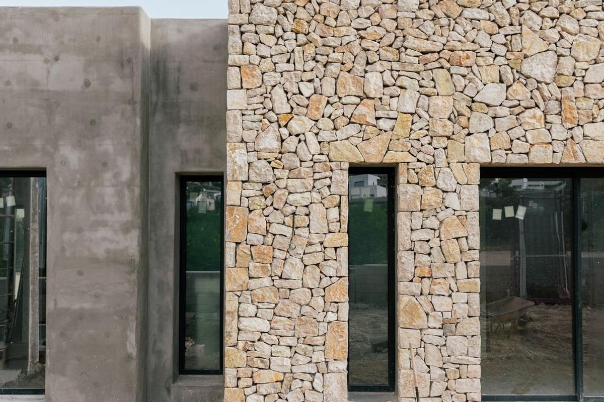 Close-up van de stenen gevel van een villa in Jávea, Costa Blanca Noord, met focus op moderne architectonische elementen.