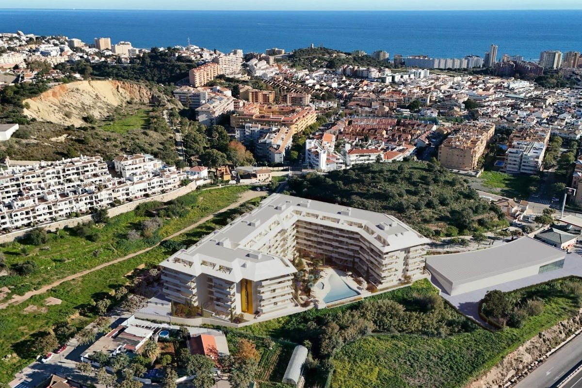 Luchtfoto van een penthousecomplex in Fuengirola, met schilderachtige omgeving en nabijheid van de kust.