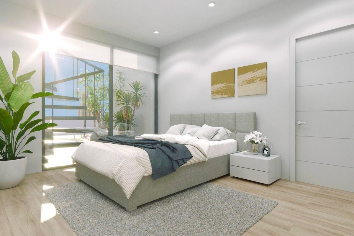 Heldere master slaapkamer met grote ramen en toegang tot het terras in een penthouse in Torrevieja.