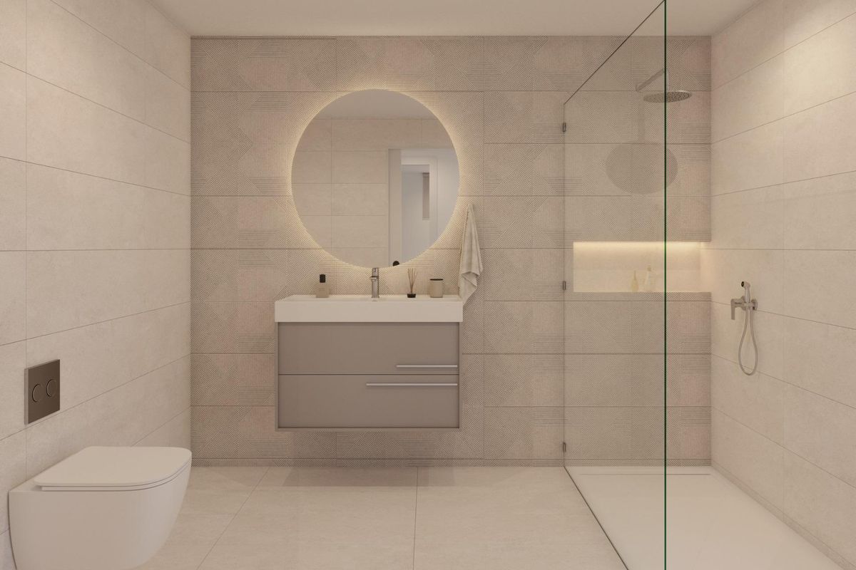 Stijlvolle badkamer met een ronde spiegel en strakke douche, ontworpen voor luxe wonen in Fuente Álamo, Spanje.