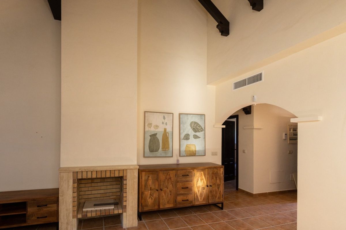 Charmante woonkamer met ingelijste kunst en houten kasten in de villa van Fuente Álamo, Spanje.