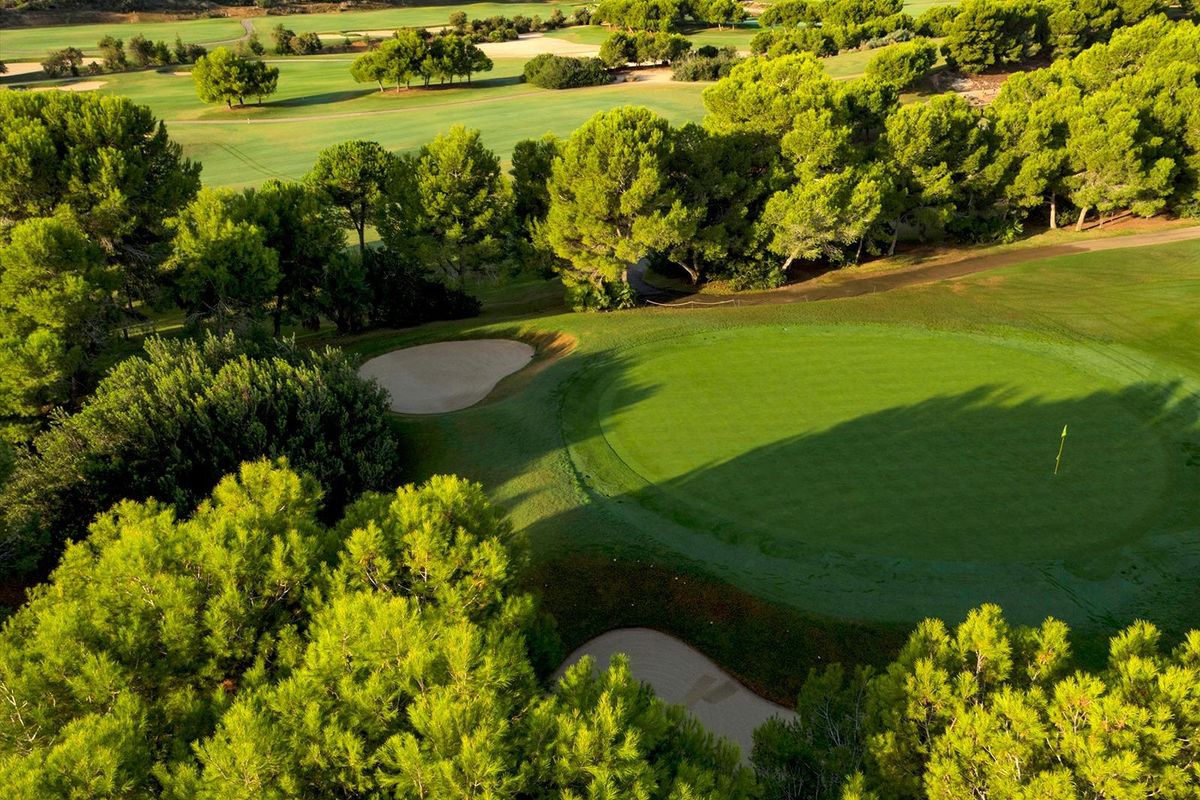 Dichtbij luchtfoto van een groene golfbaan met bunkers in Pilar de La Horadada, Costa Blanca Zuid.