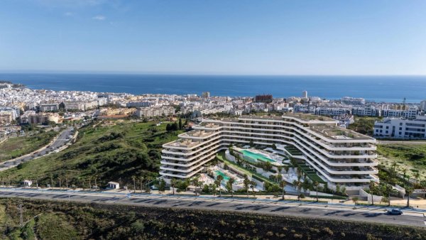 Luchtfoto van een modern appartementencomplex in Estepona met uitzicht op de oceaan en een zwembad.
