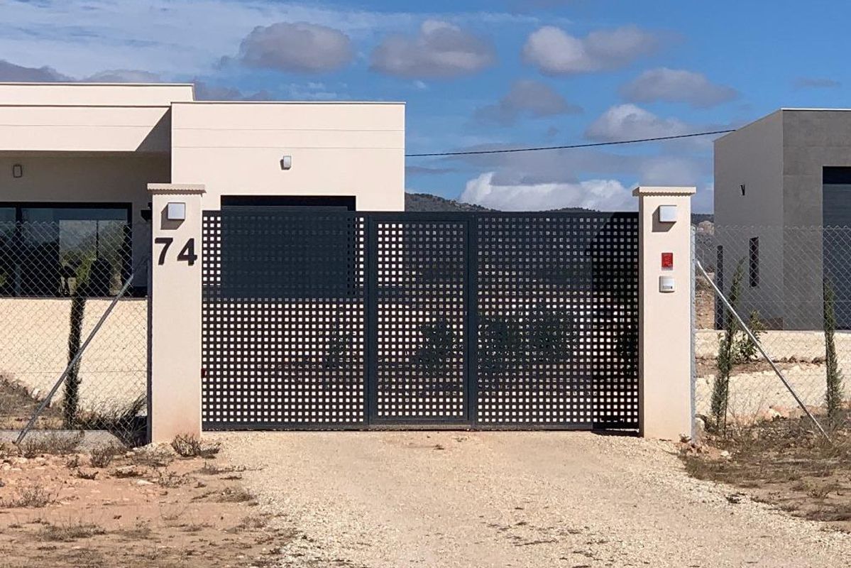 Toegangspoort tot de 4-slaapkamer villa in Pinoso, Costa Blanca, met modern hekwerk en een verwelkomend pad.