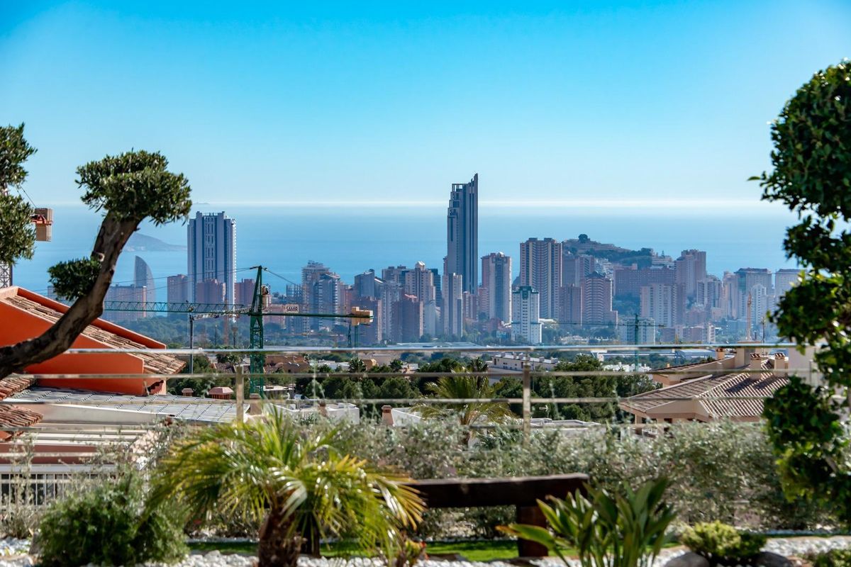 Panoramisch uitzicht vanaf de villa in Finestrat dat de stadshorizon tegen een heldere lucht toont.