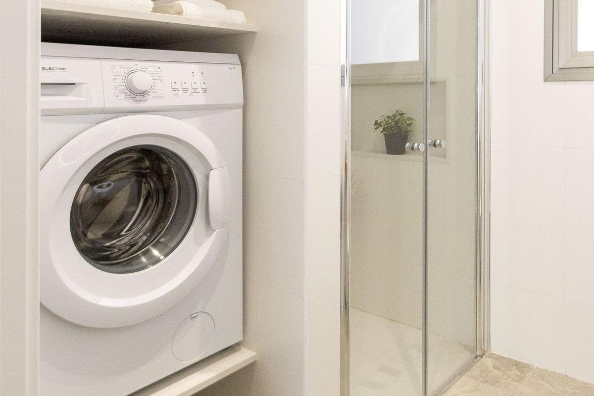 Wasruimte met eenwasmachine en douche, onderdeel van een lichte 3-slaapkamer villa in Pilar de La Horadada.