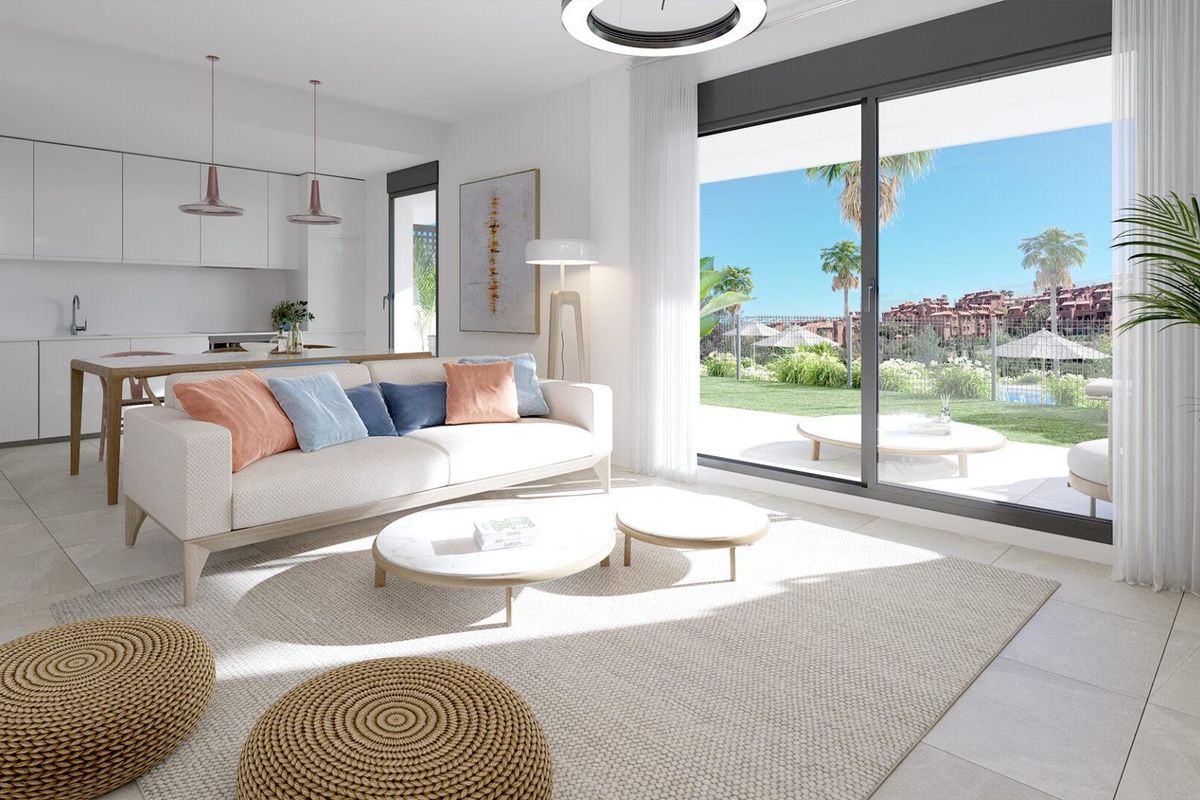 Heldere woonkamer met moderne inrichting en toegang tot de tuin in een 2-slaapkamer appartement in Estepona, Costa del Sol.